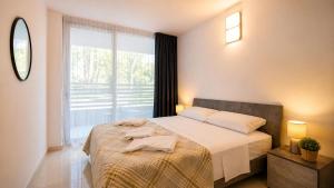a bedroom with a bed and a large window at Appartamento Residence Mimose - con parcheggio e Terrazza vicino al mare in Eraclea Mare