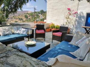 a patio with couches and a table and chairs at The Priest House in Makrotándalon