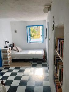 a bedroom with a bed and a window and a checkered floor at The Priest House in Makrotándalon +28 photos