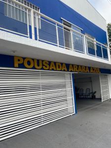 a building with a garage door with a possadaarmaarmaarmaarma sign at Hotel Arara Azul in Barra do Garças