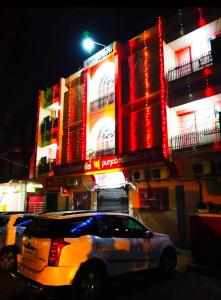 a white car parked in front of a building at night at Vandana Hotel in Dehri