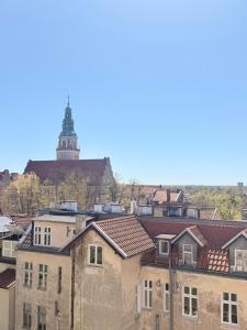 a group of buildings with a clock tower in the background at Apartamenty przy Starówce in Olsztyn