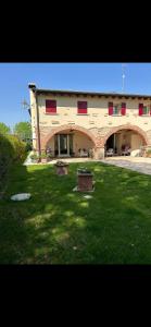 a large brick building with a yard with green grass at Dolce Vita in Altivole
