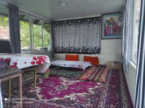a living room with a table and a rug at Guesthouse Shakirbek in Arslanbob