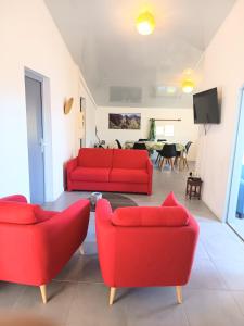 a living room with two red couches and a tv at Gîte Holidays mon repos in Saint-André +34 photos