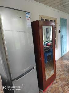 a refrigerator and a mirror in a room at Guesthouse Shakirbek in Arslanbob