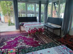 a room with two benches and a table on a rug at Guesthouse Shakirbek in Arslanbob +16 photos