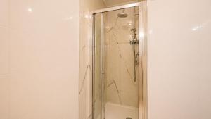 a shower with a glass door in a bathroom at Appartamento Residence Mimose - con parcheggio e Terrazza vicino al mare in Eraclea Mare +23 photos