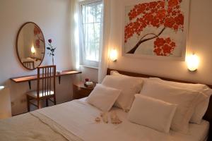 1 dormitorio con 1 cama blanca con silla y espejo en Apartment Sunny en Split