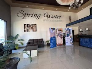 a waiting room with a sign for a spring water store at Spring Water Hotel & Suites in Cuauhtémoc