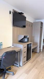 an office with a desk with a tv on a wall at Spring Water Hotel & Suites in Cuauhtémoc