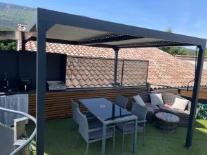 a pergola with a table and chairs on a patio at Sublime studio de caractère ,50 m2 climatisé . in Montlaur-en-Diois +1 photo
