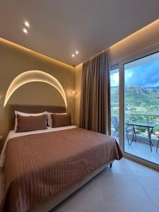 a bedroom with a bed and a balcony with a table at Ionian View B&B in Himare