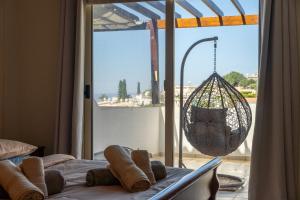 a room with a bed with a swing and a window at Peyia Hilltop Retreat - Village Views & Sunsets in Peyia +13 photos
