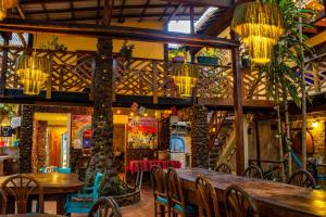 a restaurant with tables and chairs and chandeliers at Casa del Sol in Montañita +132 photos