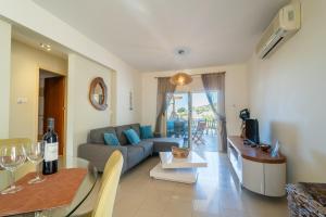 a living room with a couch and a table at Peyia Hilltop Retreat - Village Views & Sunsets in Peyia