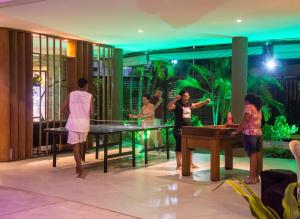 a group of people playing a game of ping pong at Mana Beach Exclusive in Porto De Galinhas +110 photos