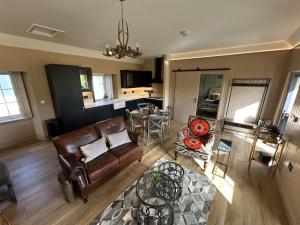 a living room with a couch and a table at Broombarns Farm Cottage in Forgandenny