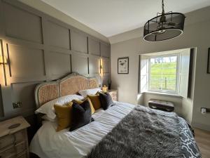 a bedroom with a large bed with pillows at Broombarns Farm Cottage in Forgandenny