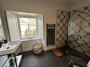 a bathroom with a shower and a sink and a window at Broombarns Farm Cottage in Forgandenny +21 photos