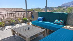 a blue couch and a table on a balcony at Ka'Zinha Guesthouse - Chambres d'hôtes Tarrafal in Tarrafal