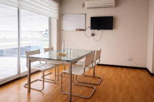 a dining room with a glass table and chairs at Hotel Safari in Iquitos