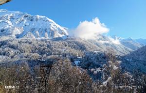 a snow covered mountain with trees in the foreground at STOP mon grand F2 face au parc des Écrins in Orcières