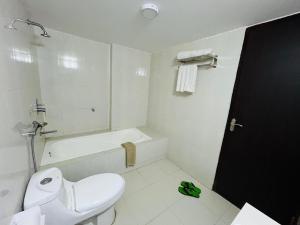 a bathroom with a toilet and a tub and a sink at Marineview Hotel Kuakata in Kuākāta