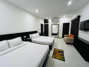 a hotel room with two beds and a television at Marineview Hotel Kuakata in Kuākāta