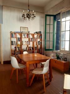 a dining room with a table and chairs and bookshelves at Vecchia Casa en el centro in General Villegas