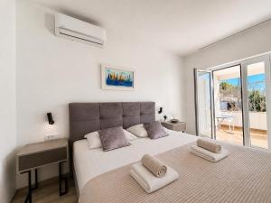 a white bedroom with a large bed with two pillows at New! Apartment Complex "S" in Čelina
