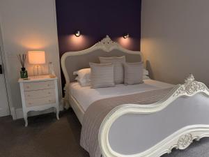 a bedroom with a large white bed and a night stand at Jacksons CafeBar & Guesthouse in Grasmere +31 photos