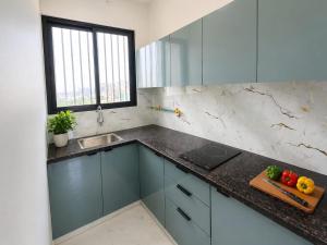 a kitchen with blue cabinets and a counter top at Lado by Stay Junction in Indore