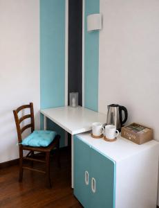 a desk with a chair and a table with a coffee pot at Villino Isò in La Spezia