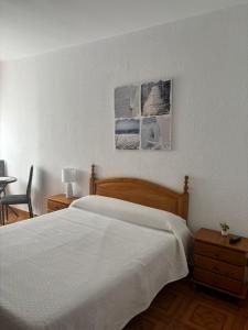 ein Schlafzimmer mit einem großen weißen Bett und einem Tisch in der Unterkunft Hostal Baviera in Pesués