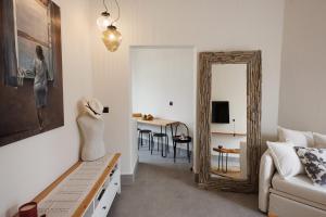 a living room with a couch and a mirror at EOS Small House in Pollonia