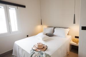 a bedroom with a white bed with a hat on it at EOS Small House in Pollonia