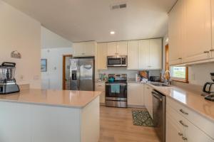 a kitchen with white cabinets and stainless steel appliances at Seagrove View - NH MP 10.5, Oceanside, 800 ft to the BEACH, YMCA Passes in Nags Head