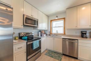 a kitchen with white cabinets and stainless steel appliances at Seagrove View - NH MP 10.5, Oceanside, 800 ft to the BEACH, YMCA Passes in Nags Head