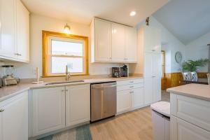 a kitchen with white cabinets and a sink and a window at Seagrove View - NH MP 10.5, Oceanside, 800 ft to the BEACH, YMCA Passes in Nags Head
