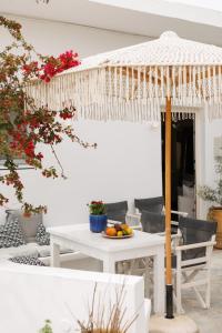 a white table with an umbrella on a patio at EOS Small House in Pollonia