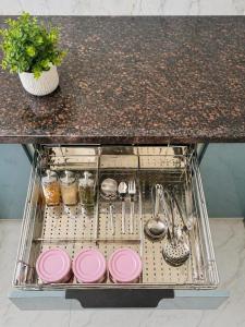 a dish drying rack with pink plates and utensils at Lado by Stay Junction in Indore