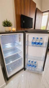 an open refrigerator filled with bottles of water at Lado by Stay Junction in Indore