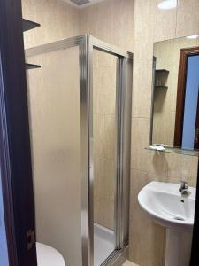 ein Badezimmer mit Dusche und Waschbecken in der Unterkunft Hostal Baviera in Pesués