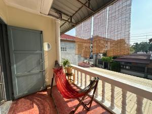 a hammock on the balcony of a house at The Station Hostel in Sathani Ayutthaya