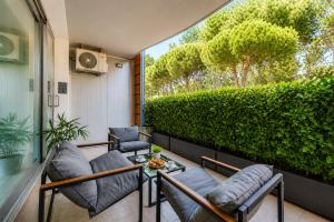 a balcony with chairs and a green hedge at Appartamento Residence Mimose - con parcheggio e Terrazza vicino al mare in Eraclea Mare