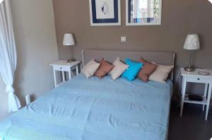 a bed with blue sheets and pillows in a bedroom at Terra Naxos in Galini