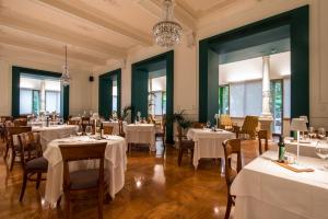 a dining room with white tables and chairs at Terme Preistoriche Resort & Spa in Montegrotto Terme