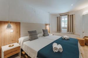 a bedroom with a large bed with two shoes on it at Apartamentos Borda D´Agua in Albufeira
