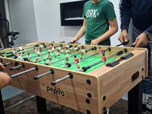 a wooden foosball table with people standing around it at BÉTA Apartman in Sárospatak +11 photos